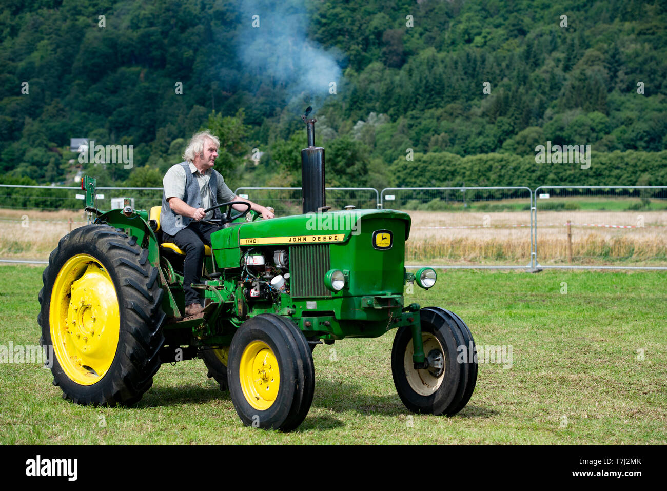 Uomo alla guida di vintage trattore John Deere, REGNO UNITO Foto Stock