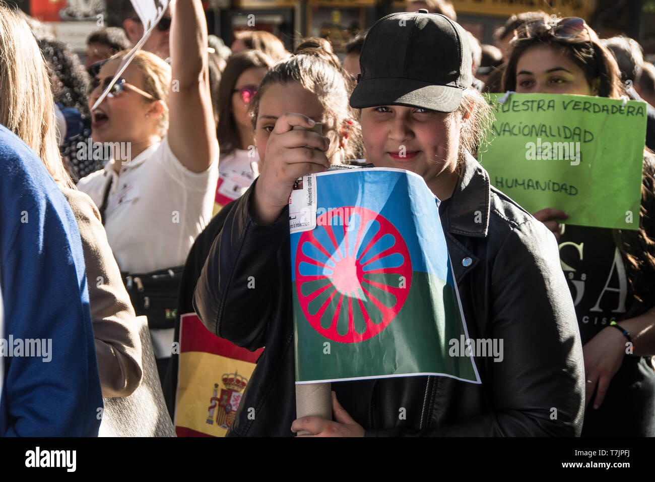 Una ragazza con una bandiera di Romani persone in manifestazioni contro il razzismo del popolo zingaro in Spagna. Foto Stock