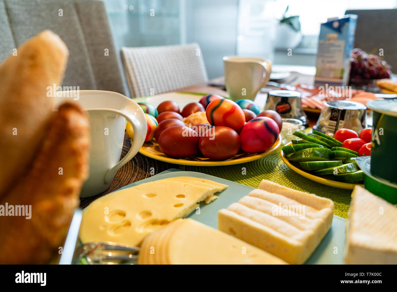 Uova colorate come un simbolo tradizionale di celebrazione di Pasqua su un tavolo per la colazione in Germania insieme con altri condimenti. Foto Stock