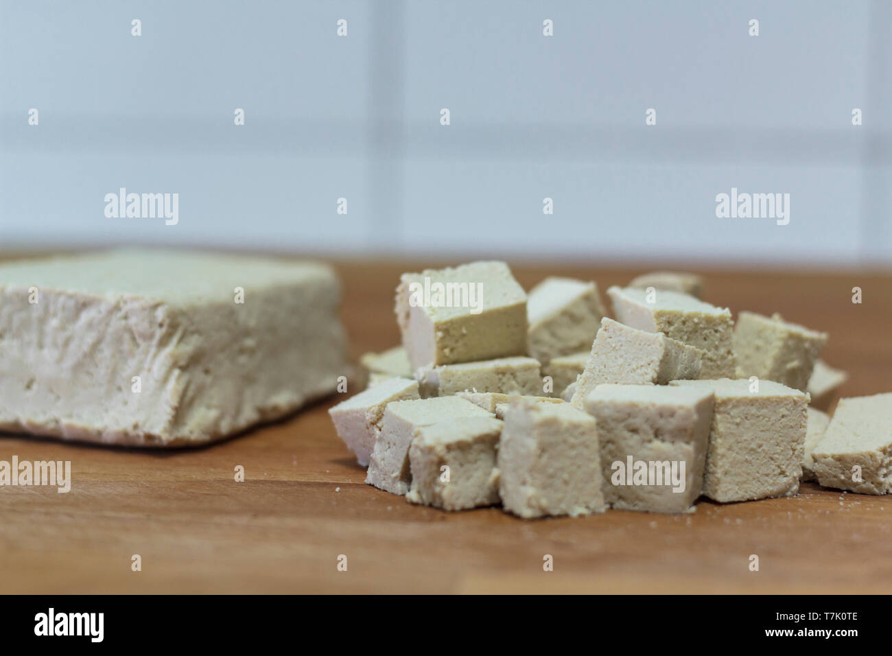 Pezzo di tofu e tagliate a dadini il tofu sulla tavola di legno Foto Stock