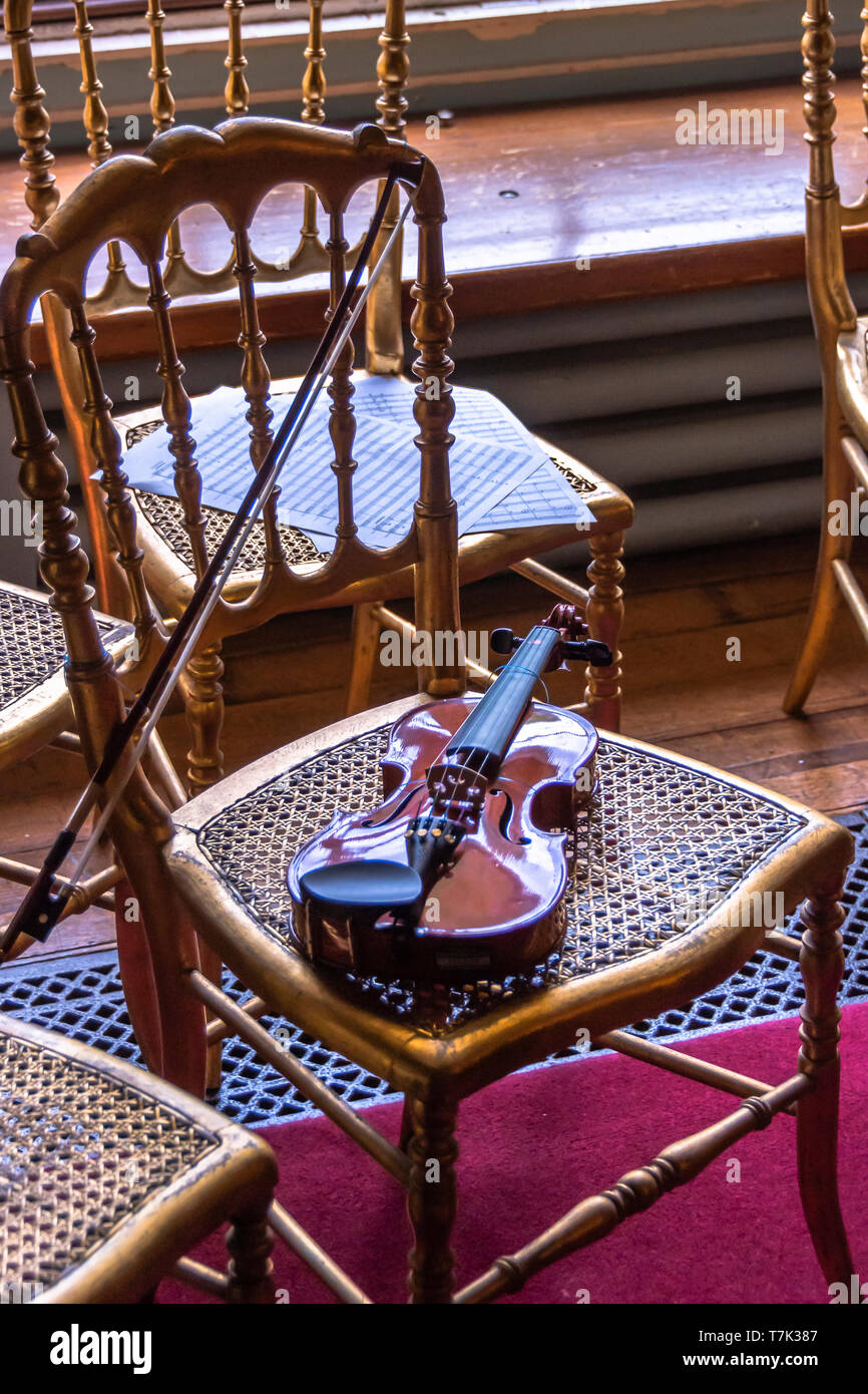 Vecchio violino su una vecchia sedia Foto Stock