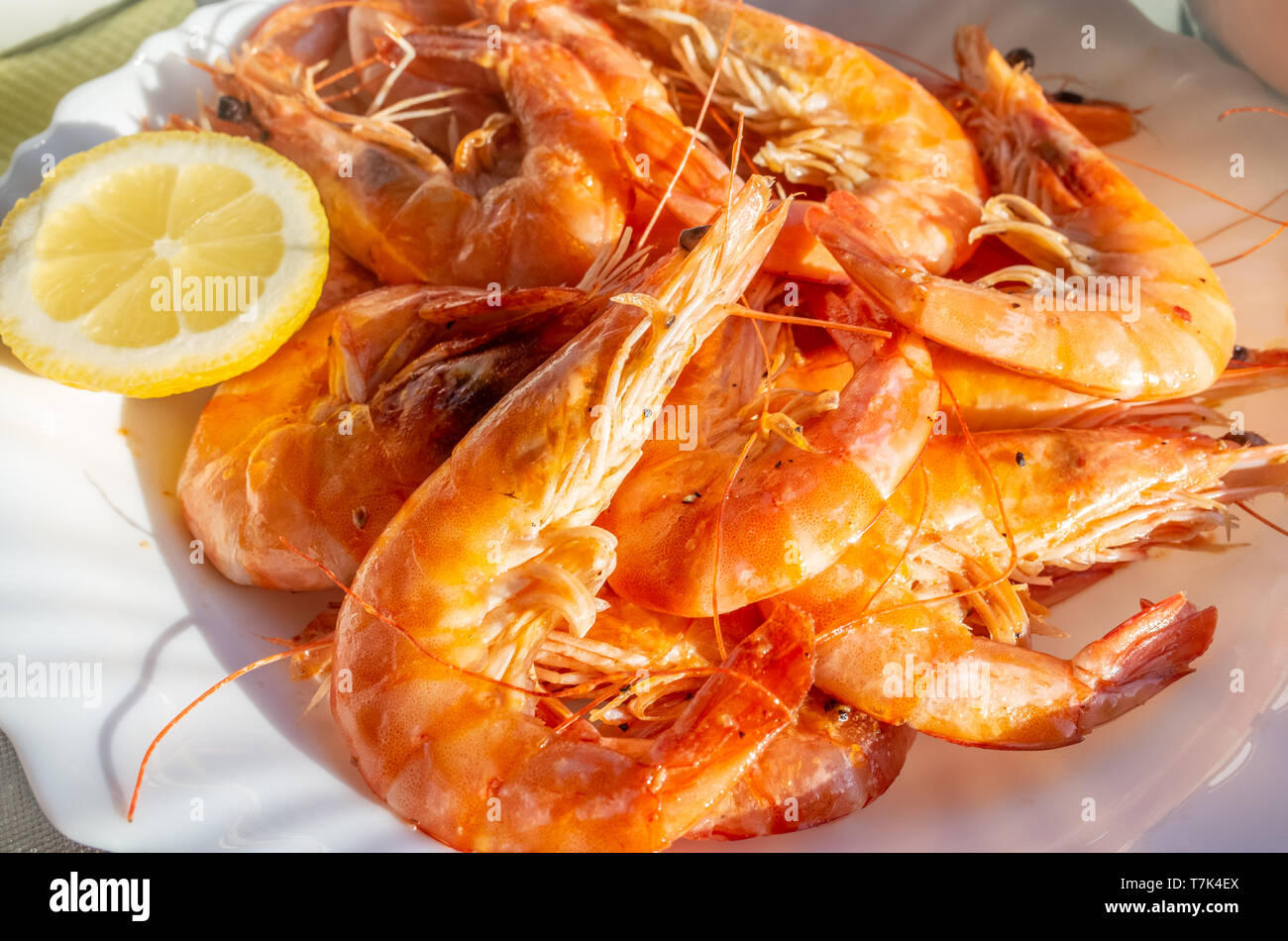 Una piastra di fresche fritte gamberoni con una fettina di limone. Foto Stock