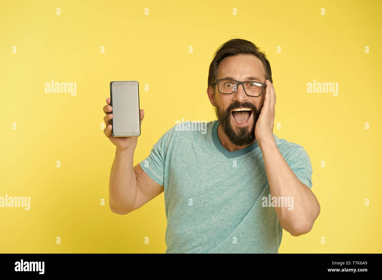 Fantastica applicazione. Guy occhiali sopraffatti dalla nuova applicazione  smartphone. Uomo Barbuto felice utente o sviluppatore consiglia di provare  l'applicazione smartphone. L uomo si prende i vantaggi di comunicazione  online Foto stock -