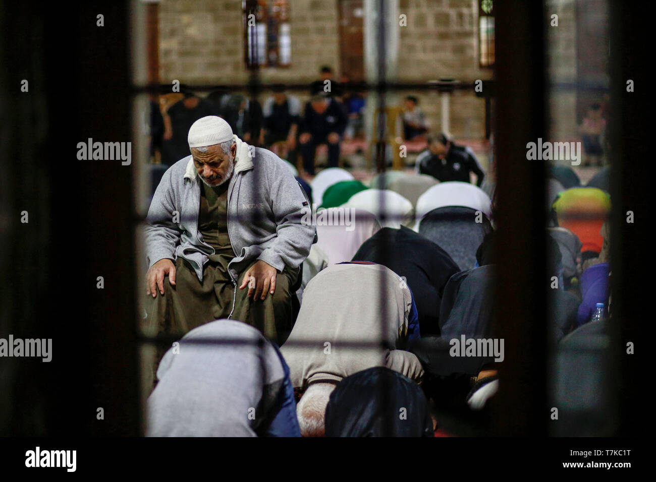 I musulmani visto che prendono parte a Taraweeh preghiere durante il Ramadan. Palestinese per i fanatici musulmani frequentano la preghiera notturna conosciuta come 'Taraweeh' alla moschea del sig. Hashim il secondo giorno dei musulmani sacro mese del Ramadan, nella città di Gaza. I musulmani di tutto il mondo celebrano il mese sacro del Ramadan pregando durante la notte e di astenersi dal mangiare e dal bere durante il periodo compreso tra gli orari di alba e tramonto. Foto Stock