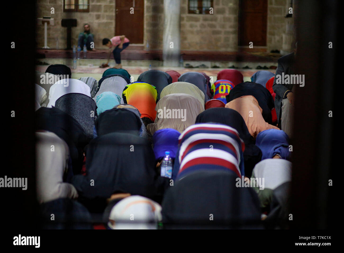 I musulmani visto che prendono parte a Taraweeh preghiere durante il Ramadan. Palestinese per i fanatici musulmani frequentano la preghiera notturna conosciuta come 'Taraweeh' alla moschea del sig. Hashim il secondo giorno dei musulmani sacro mese del Ramadan, nella città di Gaza. I musulmani di tutto il mondo celebrano il mese sacro del Ramadan pregando durante la notte e di astenersi dal mangiare e dal bere durante il periodo compreso tra gli orari di alba e tramonto. Foto Stock