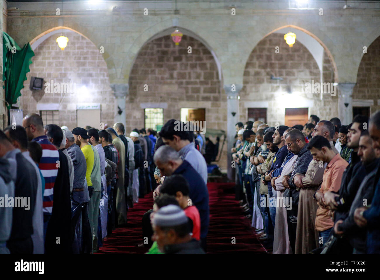 I musulmani visto che prendono parte a Taraweeh preghiere durante il Ramadan. Palestinese per i fanatici musulmani frequentano la preghiera notturna conosciuta come 'Taraweeh' alla moschea del sig. Hashim il secondo giorno dei musulmani sacro mese del Ramadan, nella città di Gaza. I musulmani di tutto il mondo celebrano il mese sacro del Ramadan pregando durante la notte e di astenersi dal mangiare e dal bere durante il periodo compreso tra gli orari di alba e tramonto. Foto Stock
