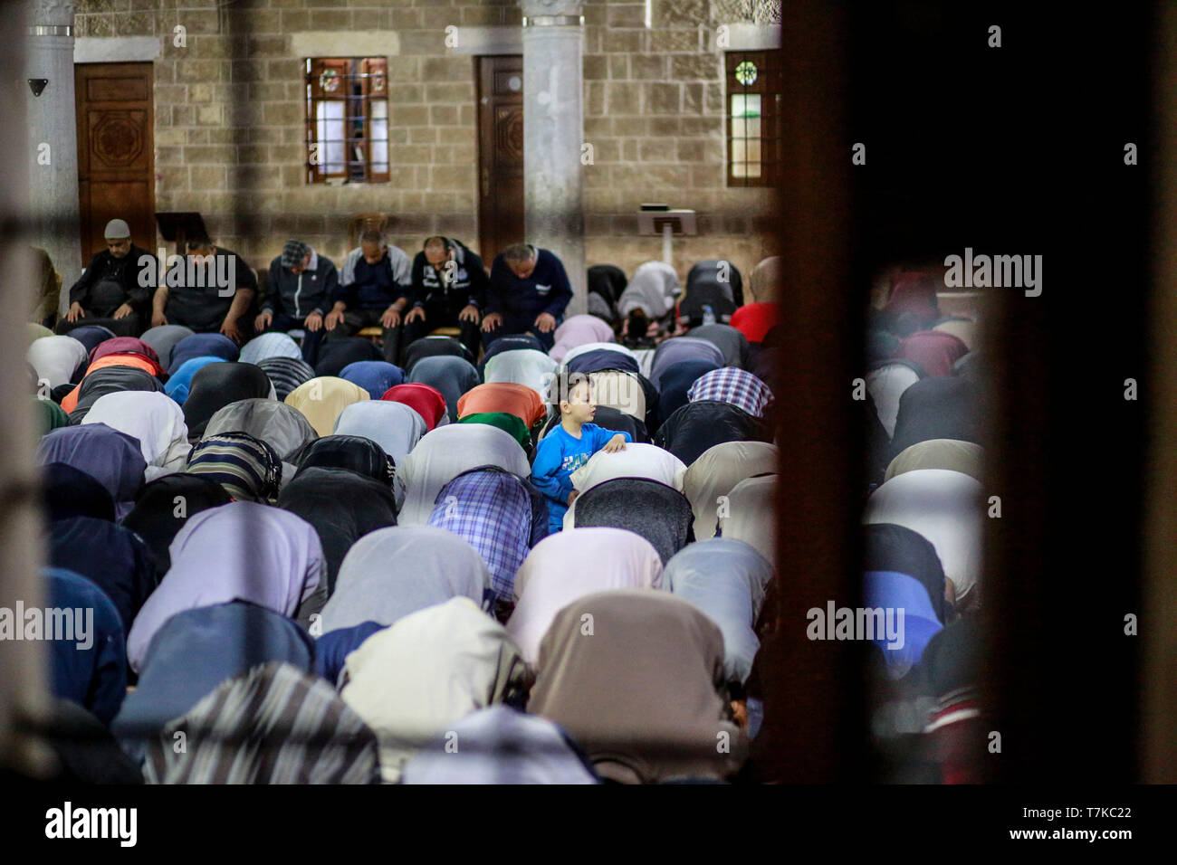 I musulmani visto che prendono parte a Taraweeh preghiere durante il Ramadan. Palestinese per i fanatici musulmani frequentano la preghiera notturna conosciuta come 'Taraweeh' alla moschea del sig. Hashim il secondo giorno dei musulmani sacro mese del Ramadan, nella città di Gaza. I musulmani di tutto il mondo celebrano il mese sacro del Ramadan pregando durante la notte e di astenersi dal mangiare e dal bere durante il periodo compreso tra gli orari di alba e tramonto. Foto Stock