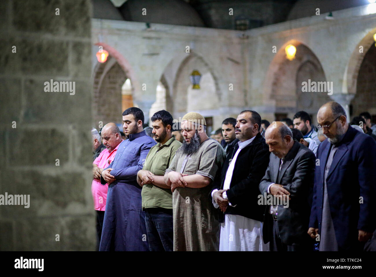 I musulmani visto che prendono parte a Taraweeh preghiere durante il Ramadan. Palestinese per i fanatici musulmani frequentano la preghiera notturna conosciuta come 'Taraweeh' alla moschea del sig. Hashim il secondo giorno dei musulmani sacro mese del Ramadan, nella città di Gaza. I musulmani di tutto il mondo celebrano il mese sacro del Ramadan pregando durante la notte e di astenersi dal mangiare e dal bere durante il periodo compreso tra gli orari di alba e tramonto. Foto Stock