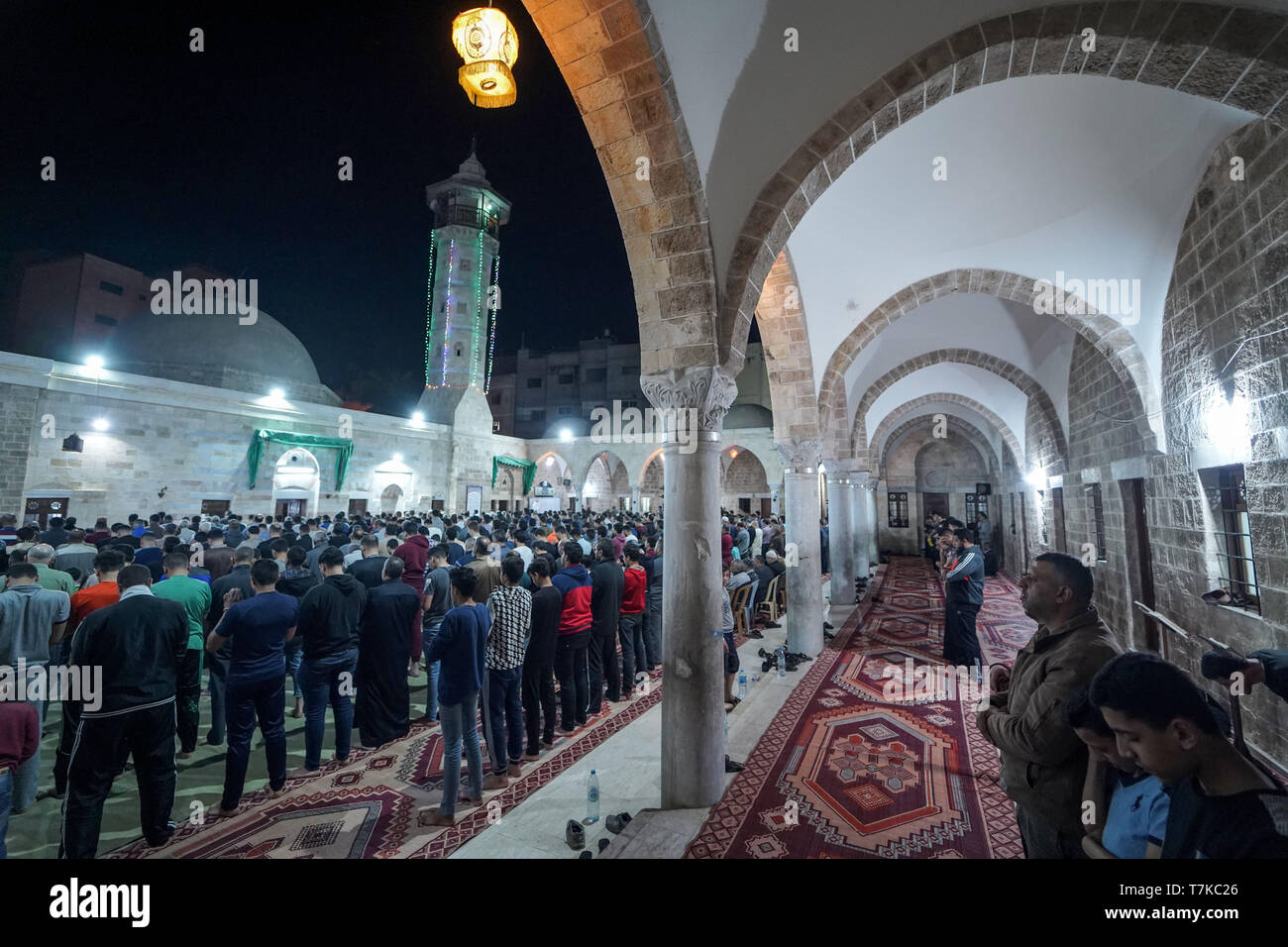 I musulmani visto che prendono parte a Taraweeh preghiere durante il Ramadan. Palestinese per i fanatici musulmani frequentano la preghiera notturna conosciuta come 'Taraweeh' alla moschea del sig. Hashim il secondo giorno dei musulmani sacro mese del Ramadan, nella città di Gaza. I musulmani di tutto il mondo celebrano il mese sacro del Ramadan pregando durante la notte e di astenersi dal mangiare e dal bere durante il periodo compreso tra gli orari di alba e tramonto. Foto Stock