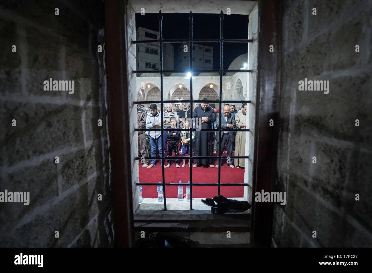I musulmani visto che prendono parte a Taraweeh preghiere durante il Ramadan. Palestinese per i fanatici musulmani frequentano la preghiera notturna conosciuta come 'Taraweeh' alla moschea del sig. Hashim il secondo giorno dei musulmani sacro mese del Ramadan, nella città di Gaza. I musulmani di tutto il mondo celebrano il mese sacro del Ramadan pregando durante la notte e di astenersi dal mangiare e dal bere durante il periodo compreso tra gli orari di alba e tramonto. Foto Stock