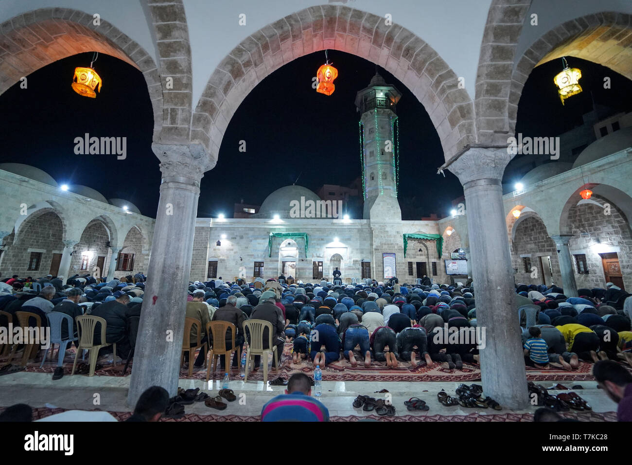 I musulmani visto che prendono parte a Taraweeh preghiere durante il Ramadan. Palestinese per i fanatici musulmani frequentano la preghiera notturna conosciuta come 'Taraweeh' alla moschea del sig. Hashim il secondo giorno dei musulmani sacro mese del Ramadan, nella città di Gaza. I musulmani di tutto il mondo celebrano il mese sacro del Ramadan pregando durante la notte e di astenersi dal mangiare e dal bere durante il periodo compreso tra gli orari di alba e tramonto. Foto Stock