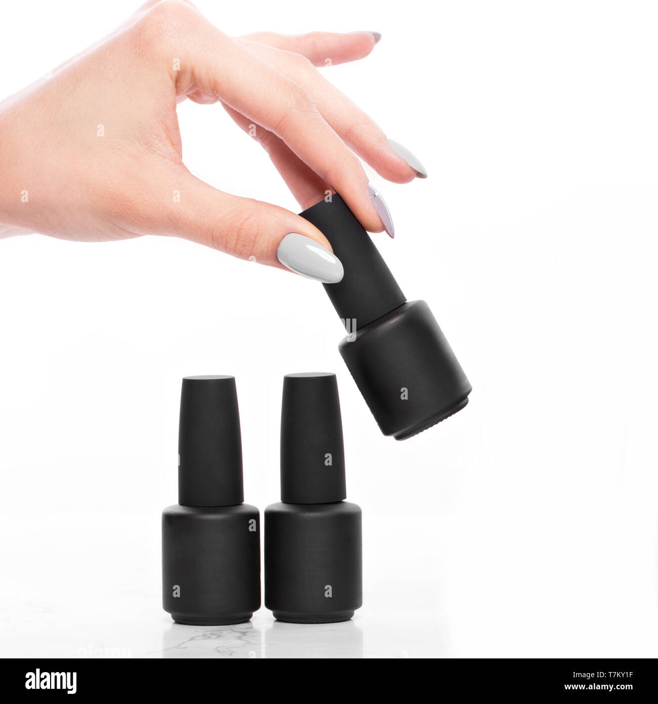 Bottiglie nere di smalto per unghie su uno sfondo bianco. Manicure design. Foto Stock