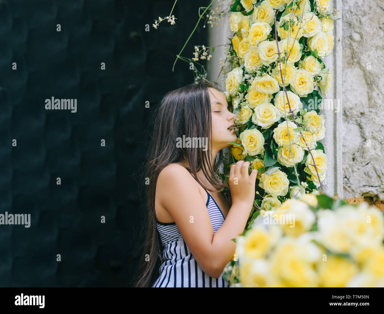 Bellissima bambina sentire il profumo dei fiori nel giardino Foto Stock