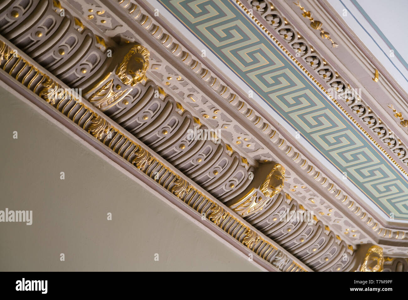 Stucco e lussuosi elementi decorativi sul soffitto. Estetica di lusso in una casa decor. Golden Lion pezzi di testa su un soffitto Foto Stock