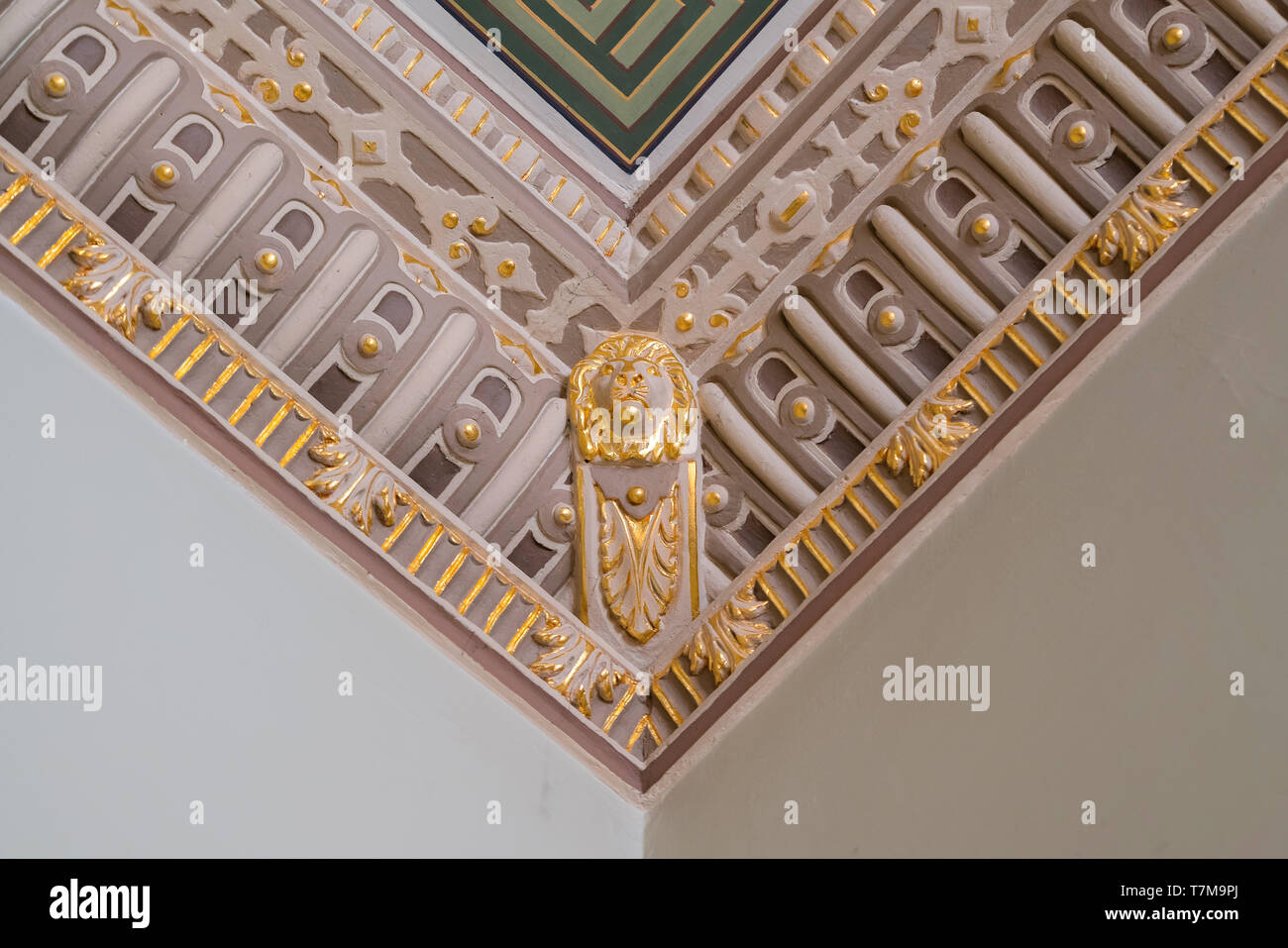 Stucco e lussuosi elementi decorativi sul soffitto. Estetica di lusso in una casa decor. Golden Lion pezzi di testa su un soffitto Foto Stock