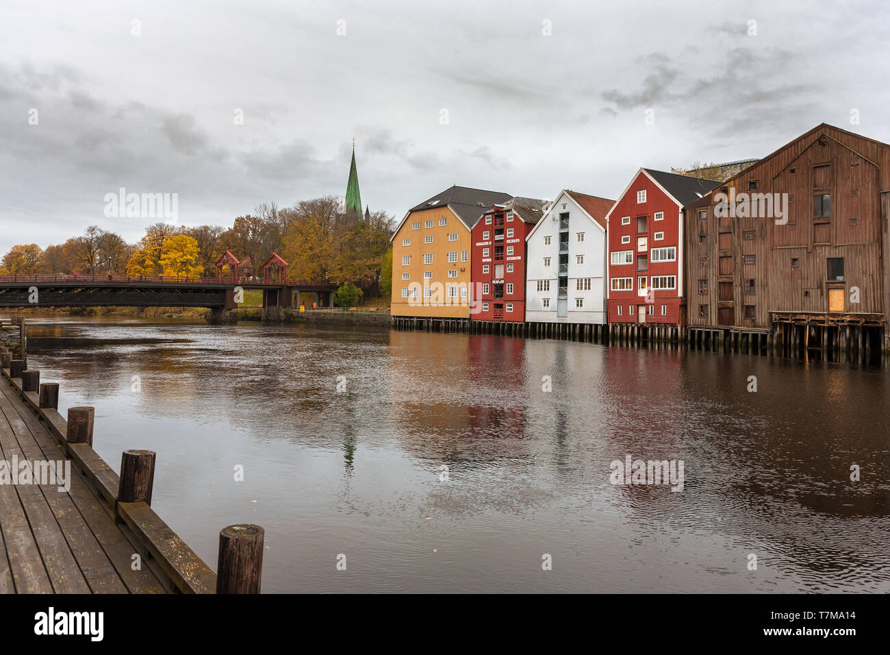 La guglia della cattedrale, la vecchia città ponte (Gamle Bybro), oltre il Fiume Nidelva, e una linea di vecchi magazzini in legno, Trondheim, Trøndelag, Norw Foto Stock