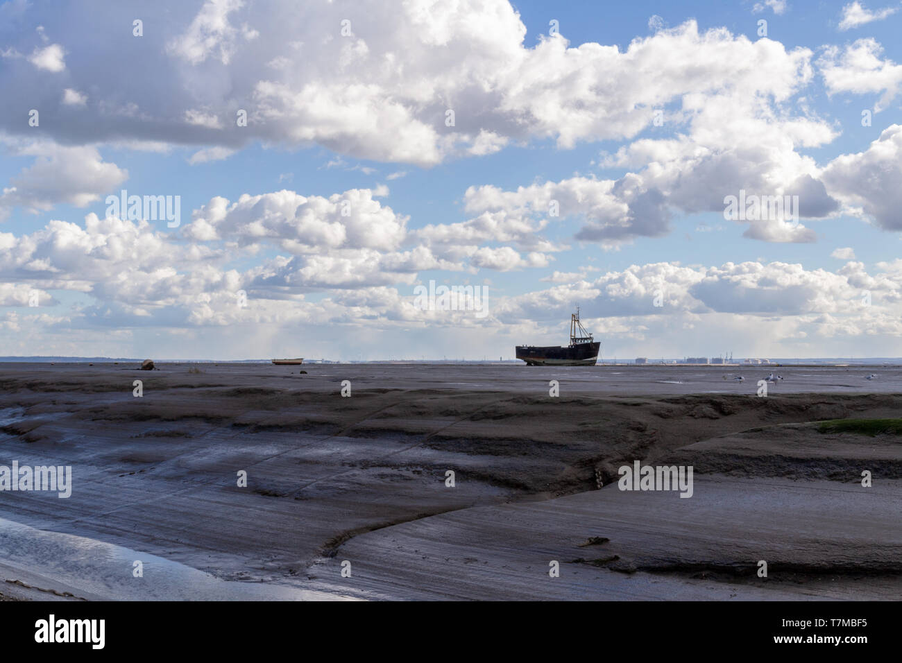 Una barca spiaggiata alla foce dell'estuario del Tamigi Foto Stock