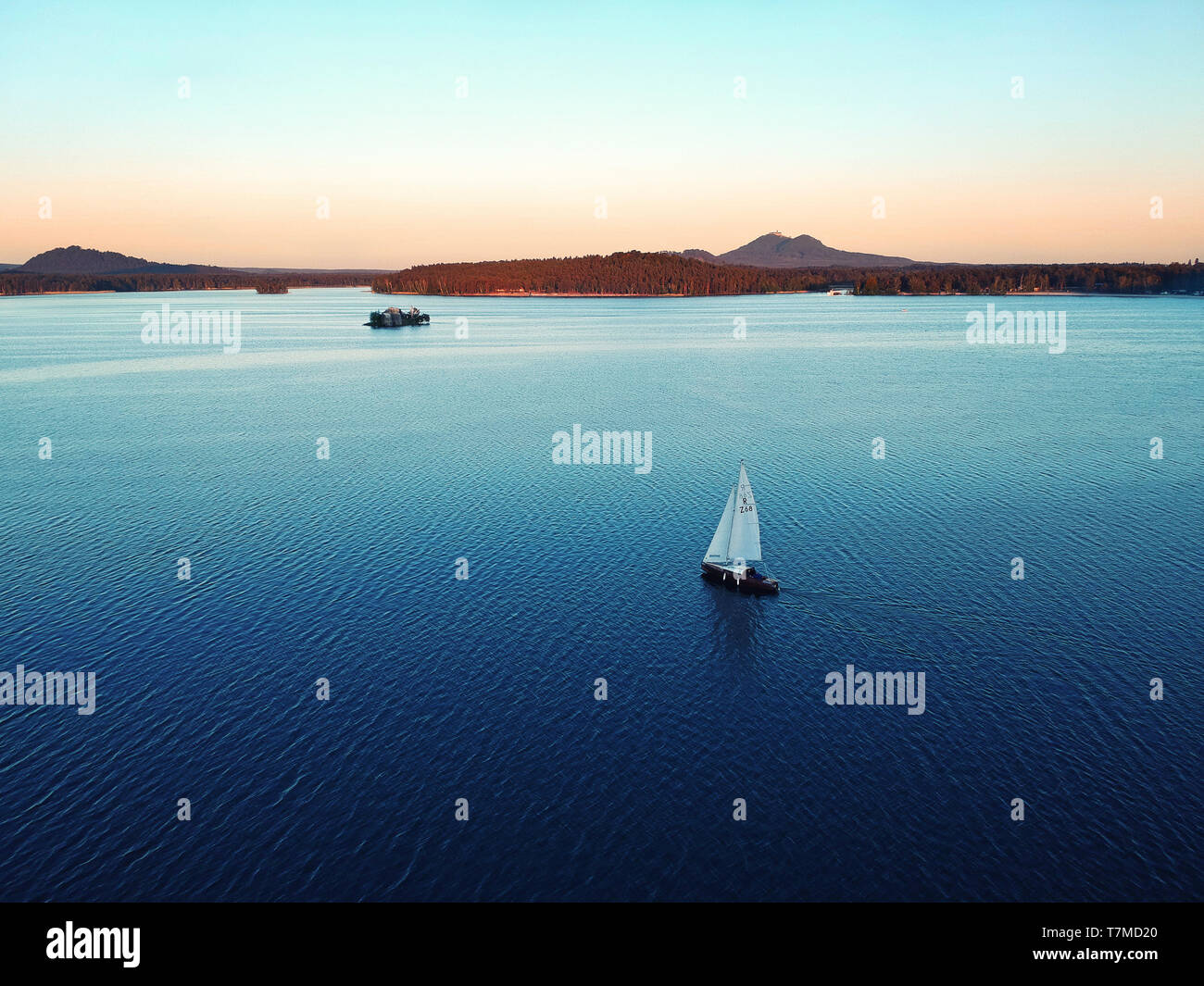 Barca sul Lago Machovo nel Kokorinsko. Dietro di lui si Bezdez Castello. C'è il tramonto. Foto Stock