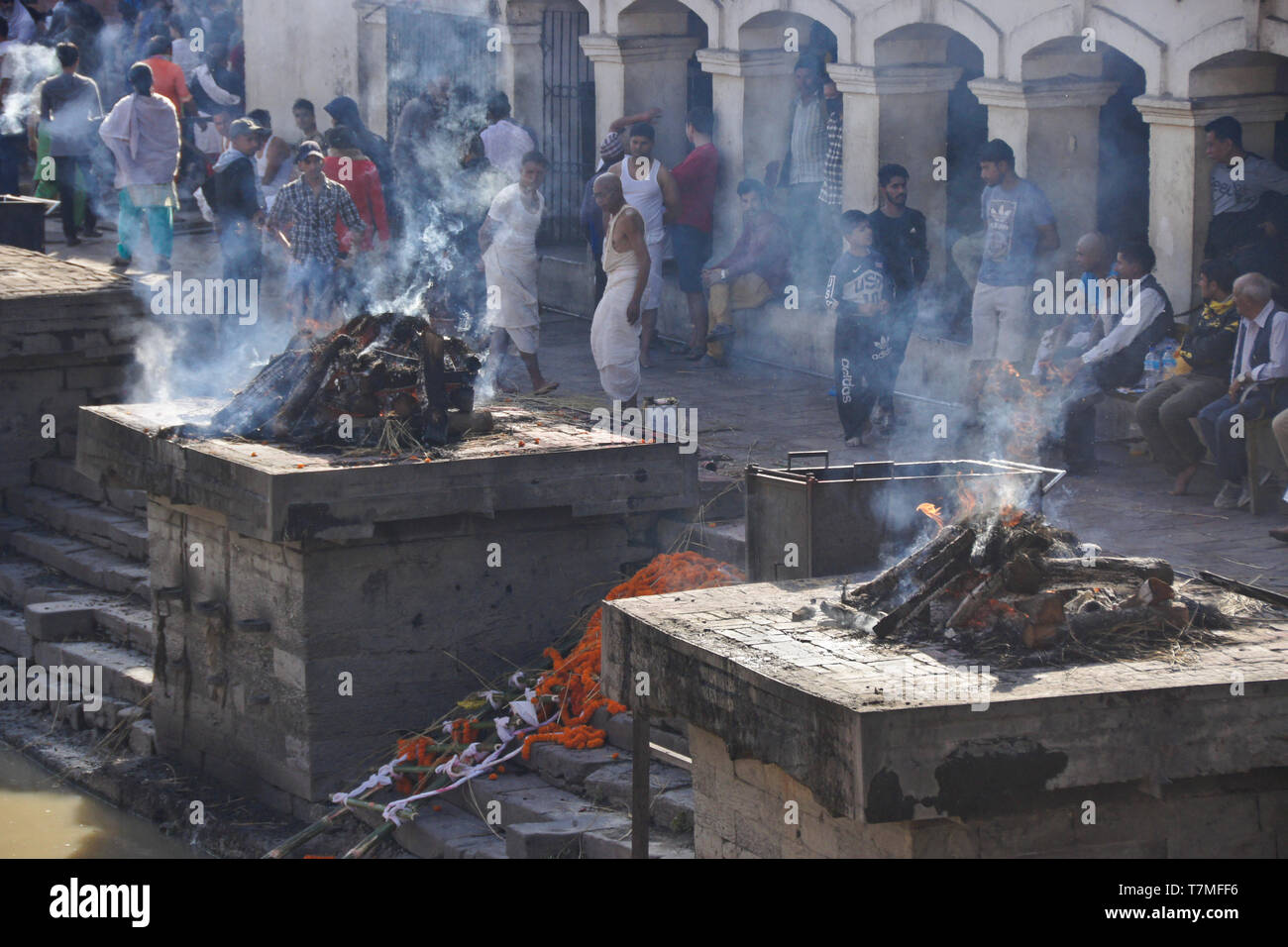 La combustione del legno per la cremazione dei corpi a ghat sul fiume Bagmati, Pashupatinath tempio indù, Kathmandu, Nepal Foto Stock