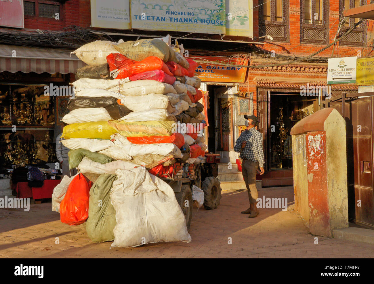 La raccolta dei rifiuti al di fuori di negozi di souvenir e ristoranti a Boudhanath, Valle di Kathmandu, Nepal Foto Stock