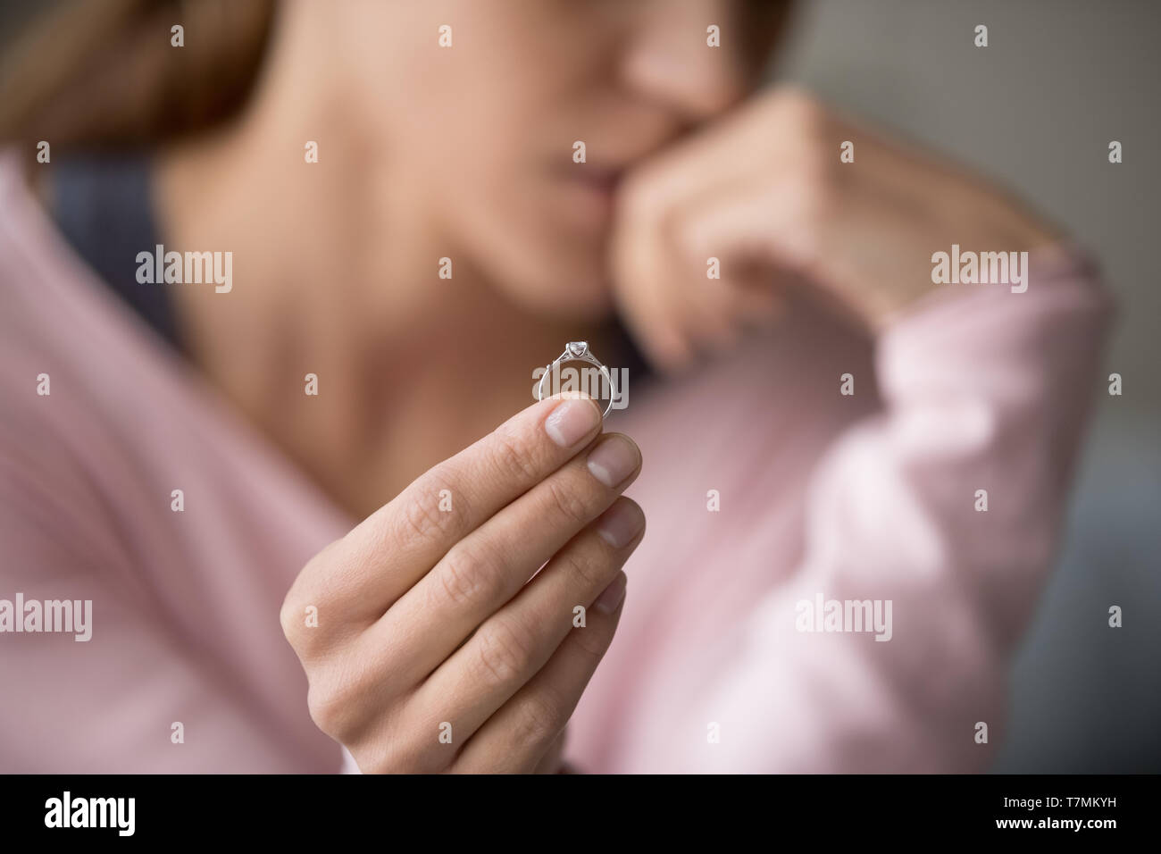 Sconvolto donna tenendo l'anello nuziale close up immagine ritagliata Foto Stock