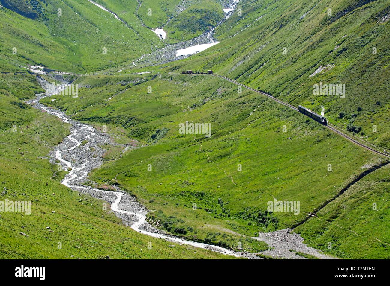 La Svizzera nel canton Vallese, treno a vapore ai piedi del Furka Pass, il Rodano scendendo dal ghiacciaio del Rodano in background Foto Stock