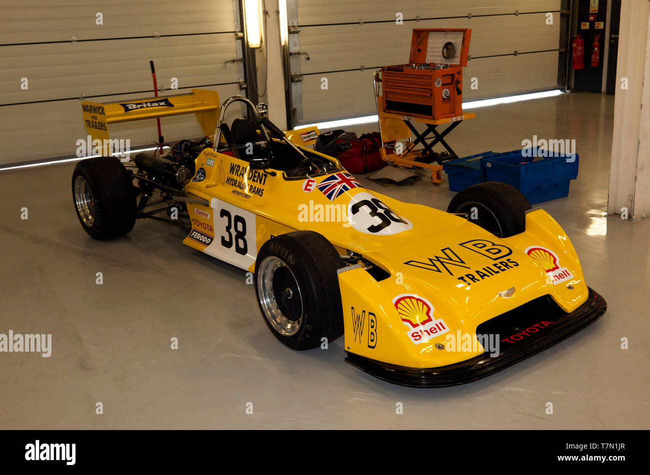 Tre quarti di vista frontale di Hugh Prezzo è giallo, 1977, Chevron B38 di Formula 3, auto nel garage Pit, durante il 2019 Silverstone Classic Media Day. Foto Stock