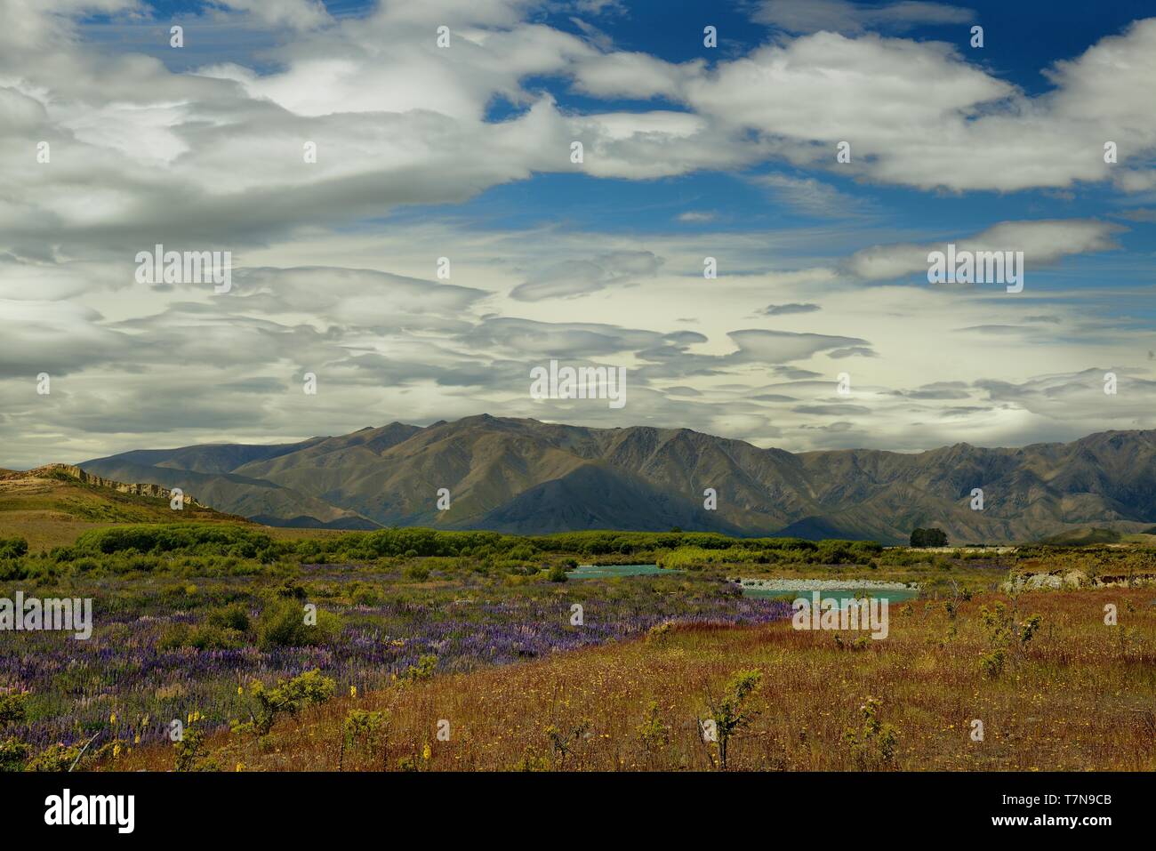 Il paesaggio della Nuova Zelanda - Isola del Sud - Paesaggio vicino a sud delle Alpi - strada tra le montagne e il cielo blu con nuvole e acqua Foto Stock