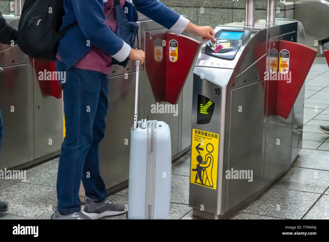 Passeggeri a piedi attraverso il pagamento della tariffa della zona di porta di uscita di Taipei dalla stazione della metropolitana, mentre toccando il loro trasporto pubblico schede di IC, in Taipei, Taiwan Foto Stock