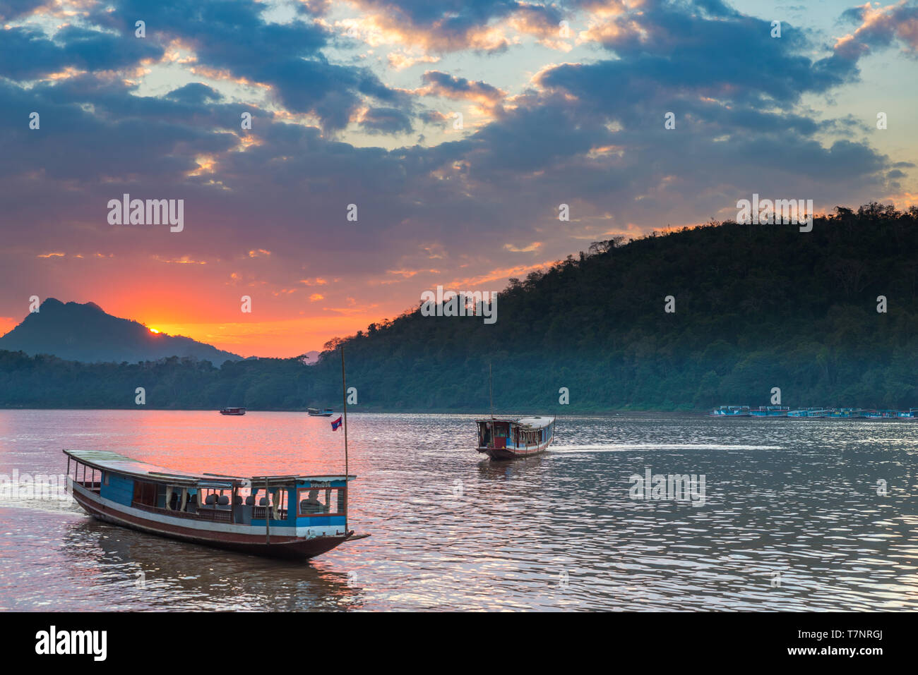 Barche sul fiume Mekong a Luang Prabang, Laos, tramonto Cielo drammatico, famosa destinazione di viaggio backpacker nel Sud Est asiatico Foto Stock