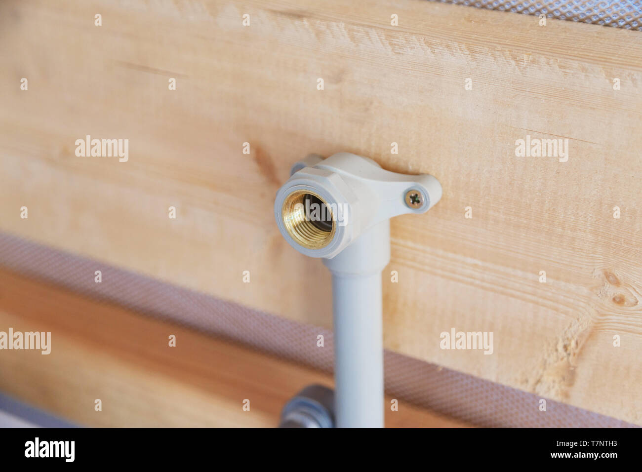 Tubazioni di alimentazione acqua fissata sulla parete in legno Foto Stock