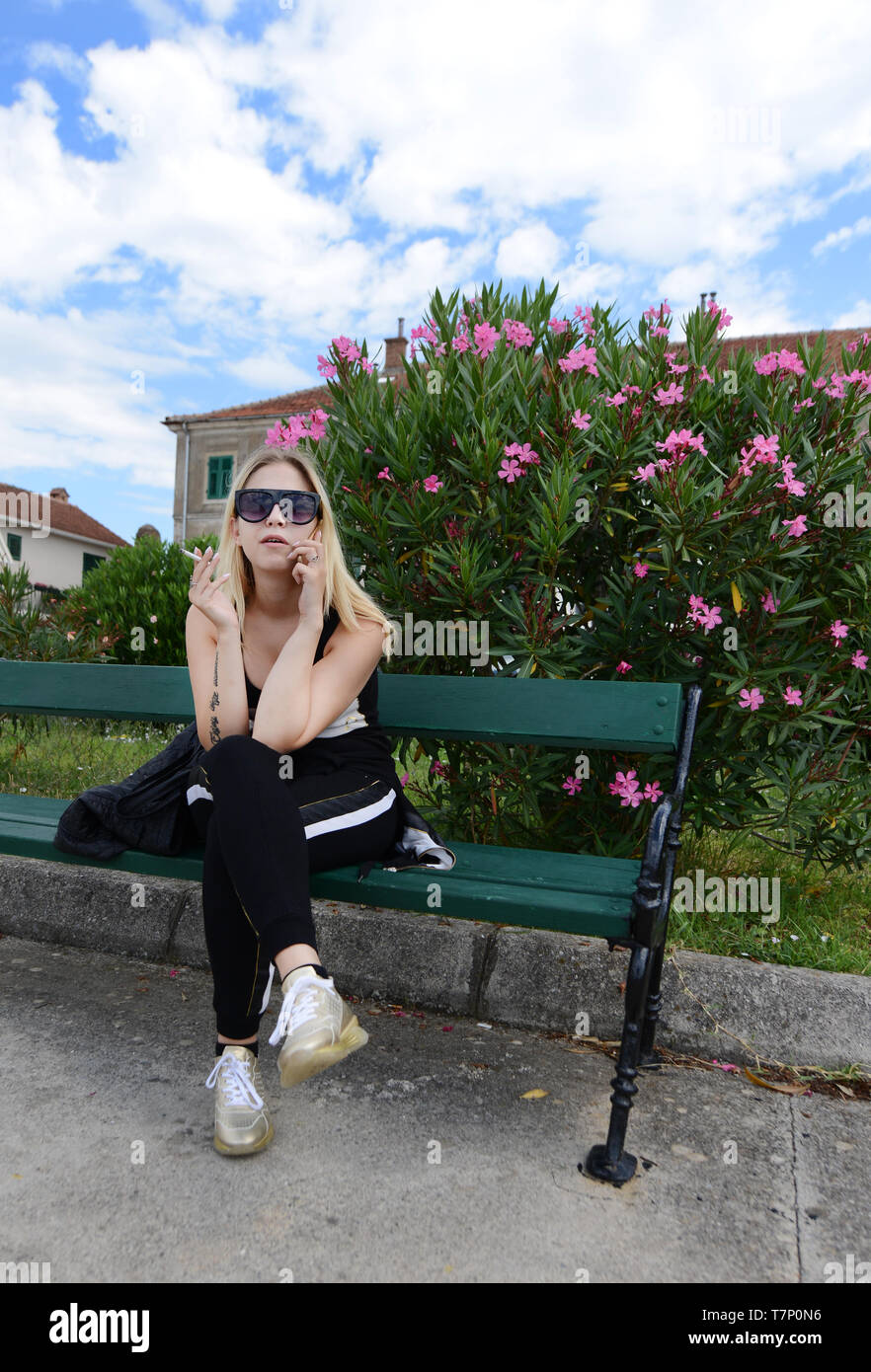 Una moda donna montenegrino di fumare una sigaretta. Foto Stock