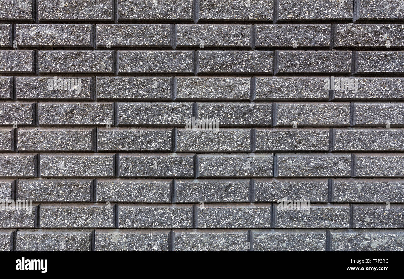 La texture della parete è fatta di mattoni grigi stesi orizzontalmente Foto Stock