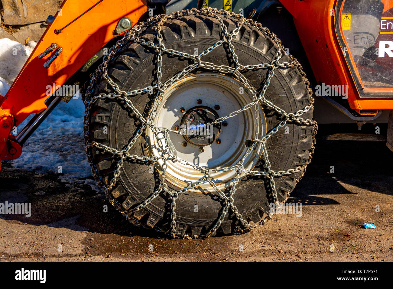 Metallo catene da neve sulla ruota di una rimozione della neve veicolo Foto Stock