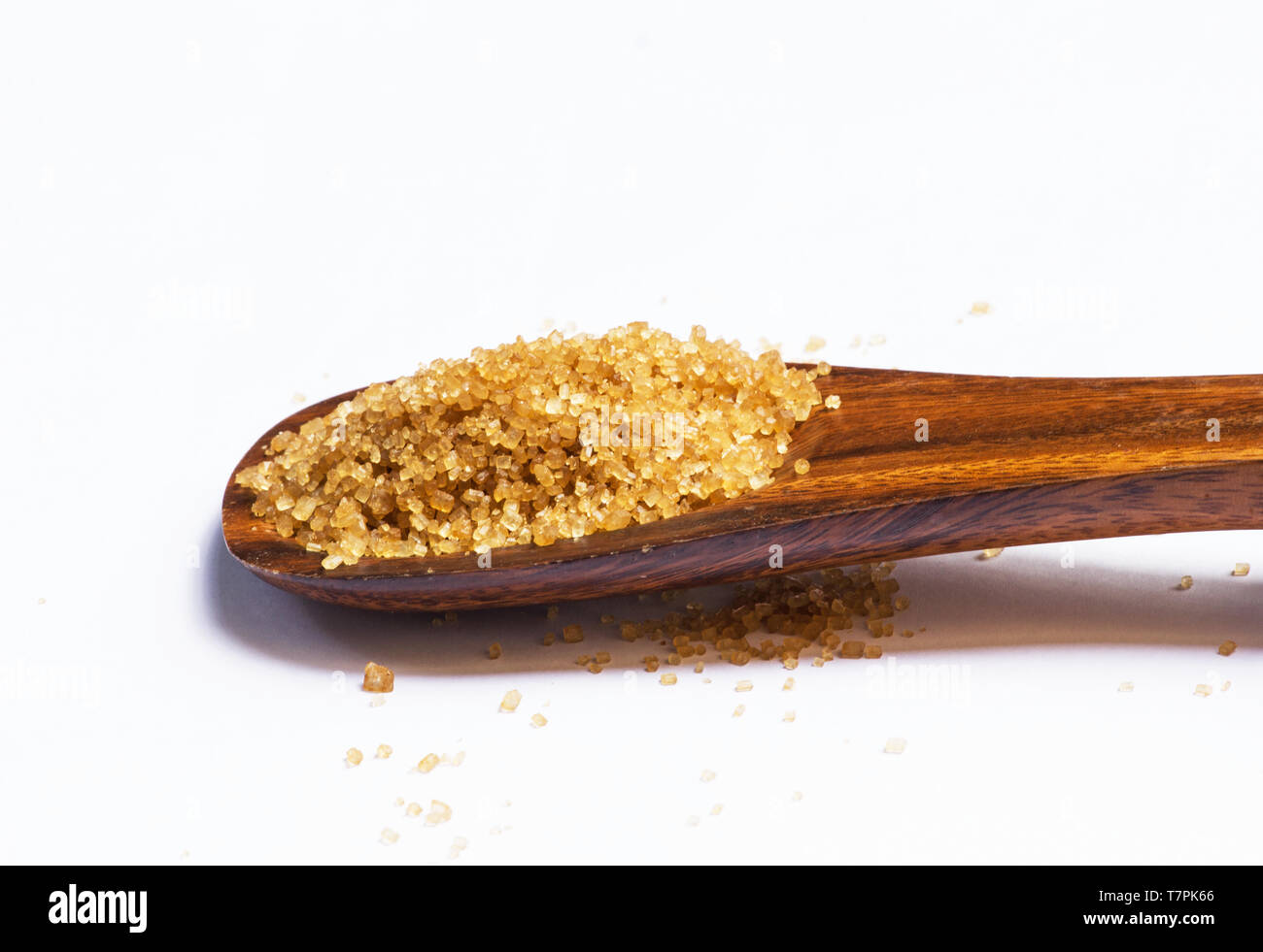 Lo zucchero di canna in un cucchiaio di legno su sfondo bianco Foto Stock