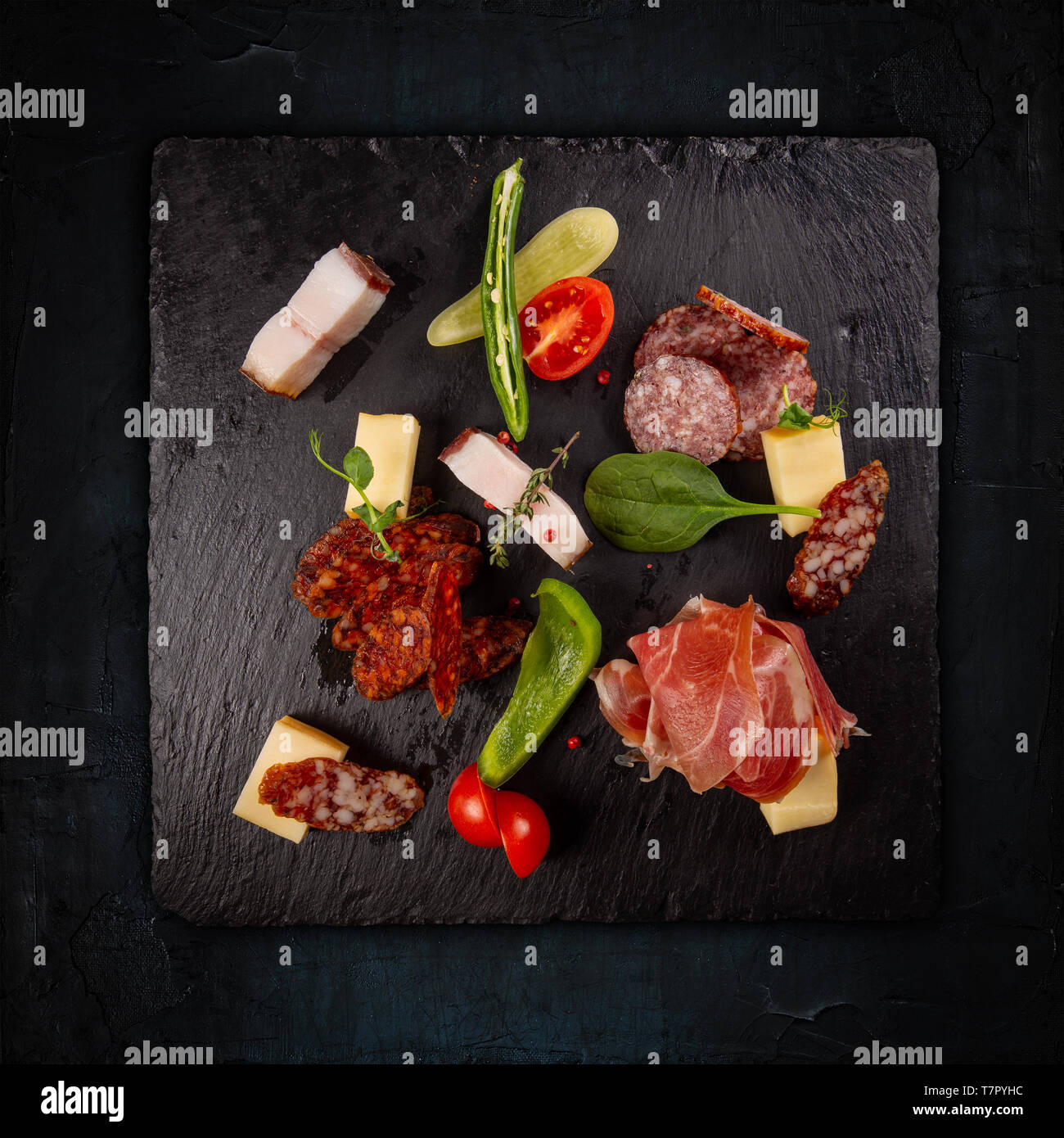 Varietà di salumi, salsicce e bacon servita su una scheda di ardesia Foto Stock