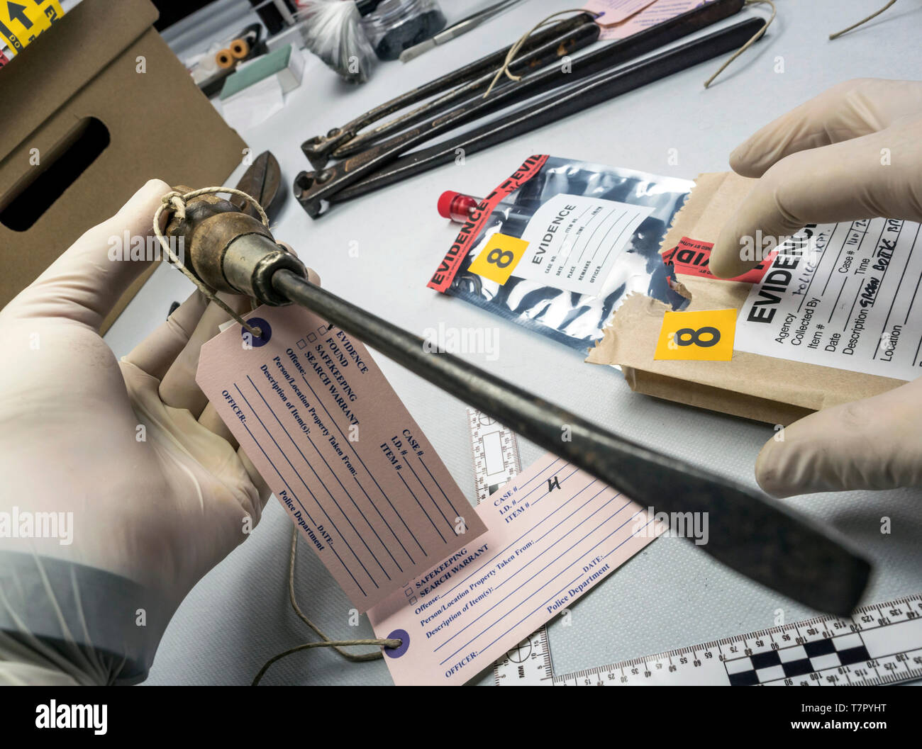 La polizia di esperti esamina con la lente di ingrandimento di un cacciavite nel laboratorio di medicina legale attrezzature, immagine concettuale Foto Stock