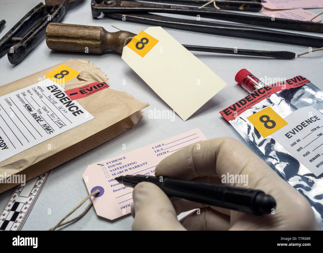 Esperto di polizia scrive su etichetta numero di prove, vari test di laboratorio forense, equipaggiamento immagine concettuale Foto Stock