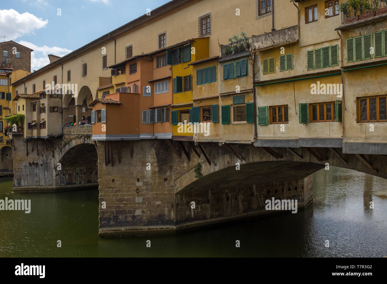 Una vista da vicino dal lato del famoso Ponte Vecchio, il ponte che attraversa il fiume Arno a Firenze è stata l'unica a non essere distrutto a Firenze durante la II guerra mondiale, luminoso cielo blu e completamente bianco delle nuvole Foto Stock