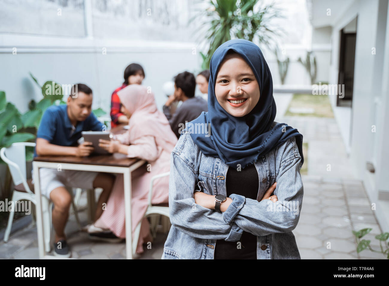 La donna musulmana ha attraversato il suo braccio sorridente Foto Stock