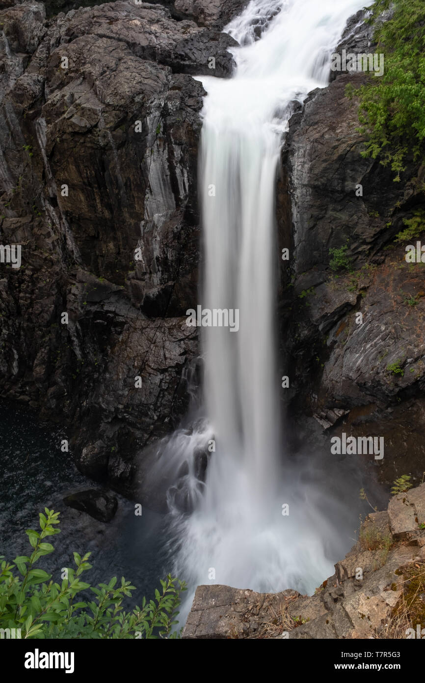 Un un unico grande goccia waterfall cascading nel fiume sottostante, una lunga esposizione shot per smussare la cascata d'acqua Foto Stock