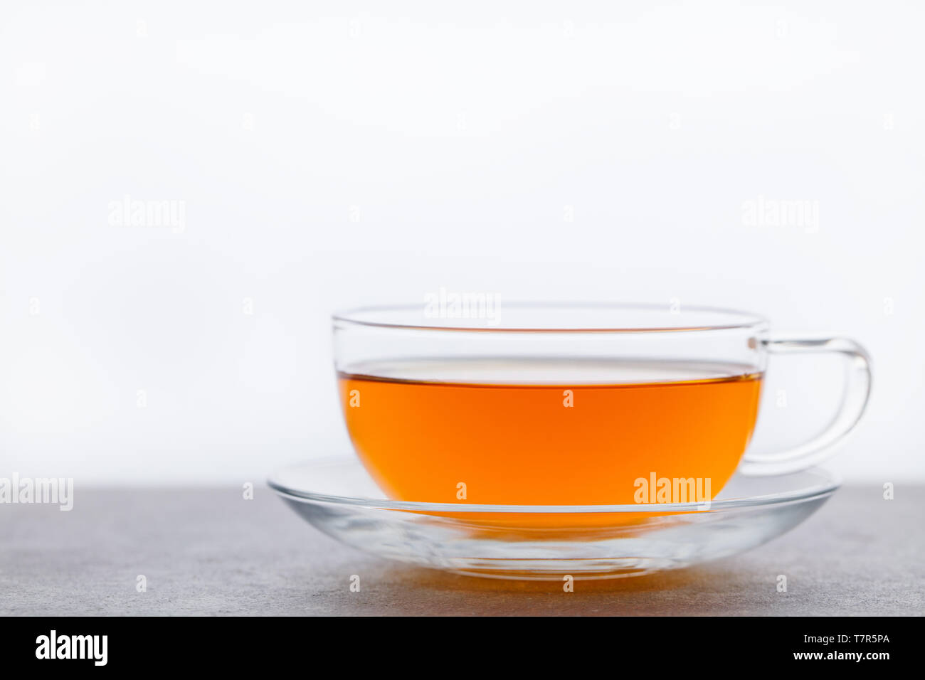 Il tè in tazza di vetro. Sfondo grigio. Copia dello spazio. Foto Stock