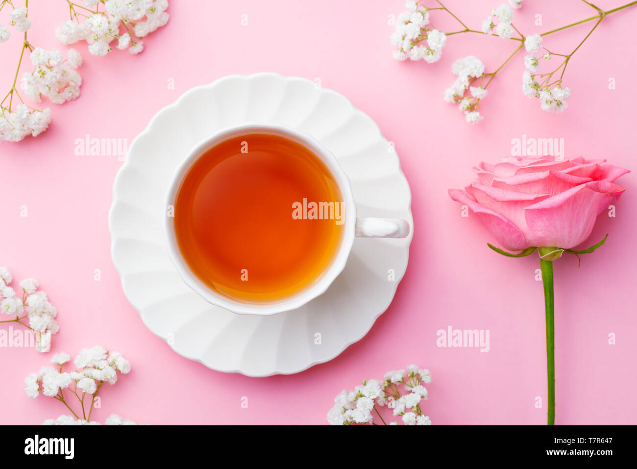 Tazza di tè con fiori freschi su sfondo rosa. Copia dello spazio. Vista dall'alto. Foto Stock