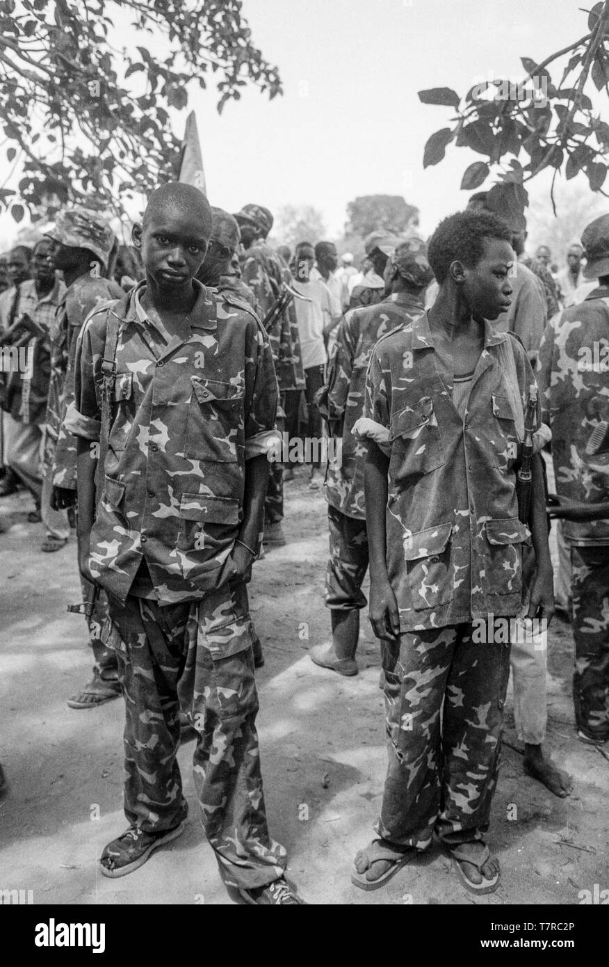 Ex bambini soldato scopre per la parata in una piccola città di Malual kon in sud Sudan. Il SPLA (popolo Sudanese Liberation Army) prende parte a un raduno di pace per dimostrare la loro accettazione dell'accordo di pace stabilisce le loro braccia. Foto Stock