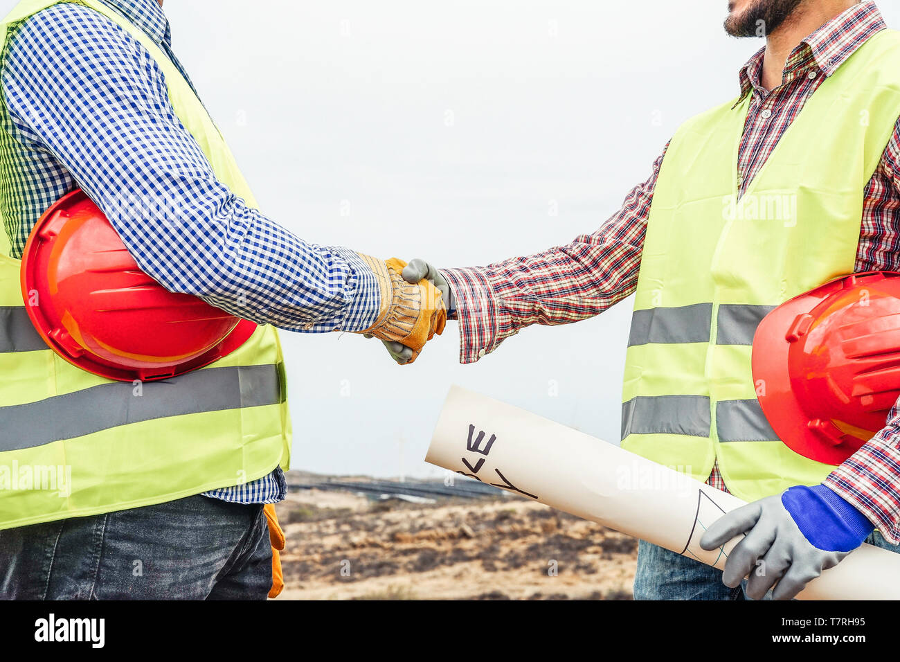Costruttori stringono le mani facendo un accordo sulla costruzione del sito - Lavoratori di raggiungere un accordo sul progetto di energia rinnovabile sul sito di lavoro Foto Stock