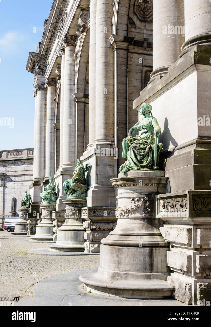 Vista ravvicinata delle statue alla base delle colonne sul lato orientale del porticato du Cinquantenaire, l'arco trionfale a Bruxelles, in Belgio. Foto Stock