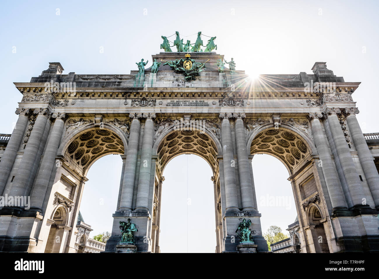 Basso angolo di visione dell'arcade du Cinquantenaire, l'arco trionfale nel parco del Cinquantenario di Bruxelles in Belgio contro la luce del sole. Foto Stock