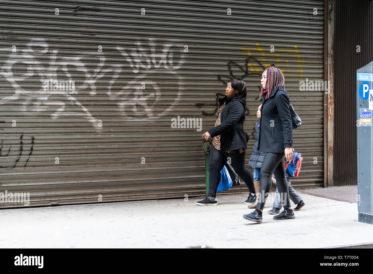 New York City - Aprile 6, 2018: occupato persone donne camminando sul marciapiede marciapiede dal garage chiuso a New York Midtown Foto Stock