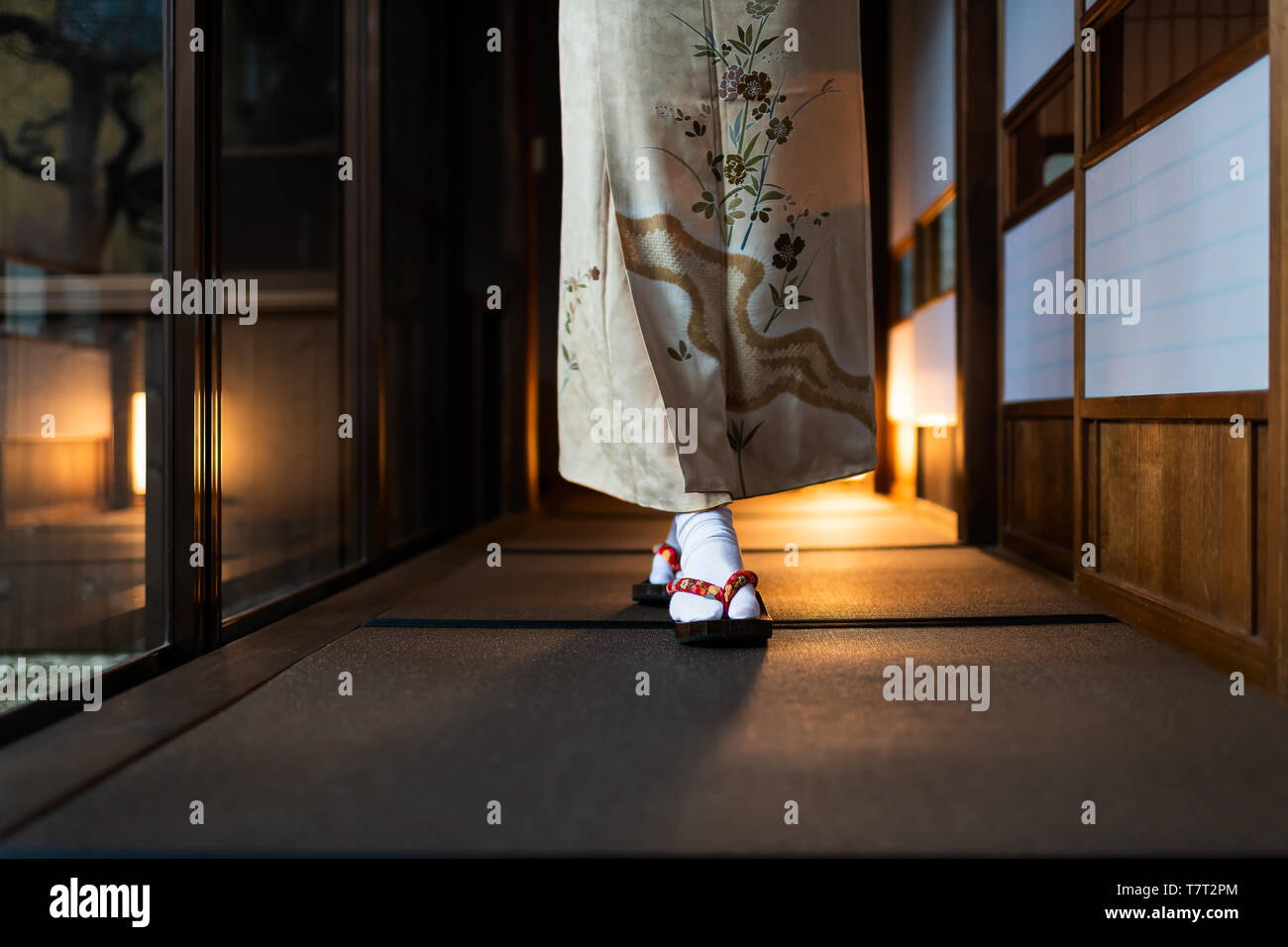 Casa tradizionale giapponese o ryokan con pavimento in tatami pavimento e porte scorrevoli di carta shoji e donna in kimono e geta scarpe dei tabi calzini a piedi Foto Stock
