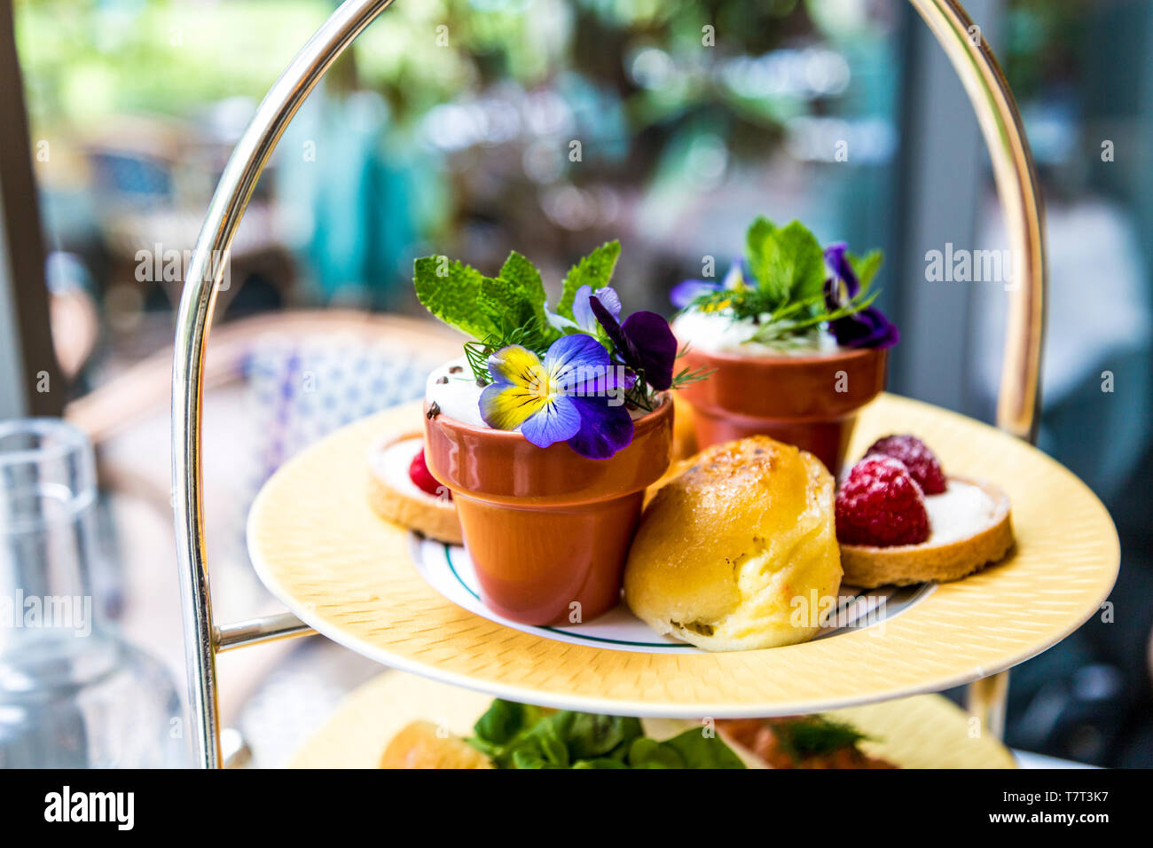 Ciambella, mousse e cheesecake su un vassoio, il tè del pomeriggio a Ivy nel Parco di Canary Wharf, London, Regno Unito Foto Stock